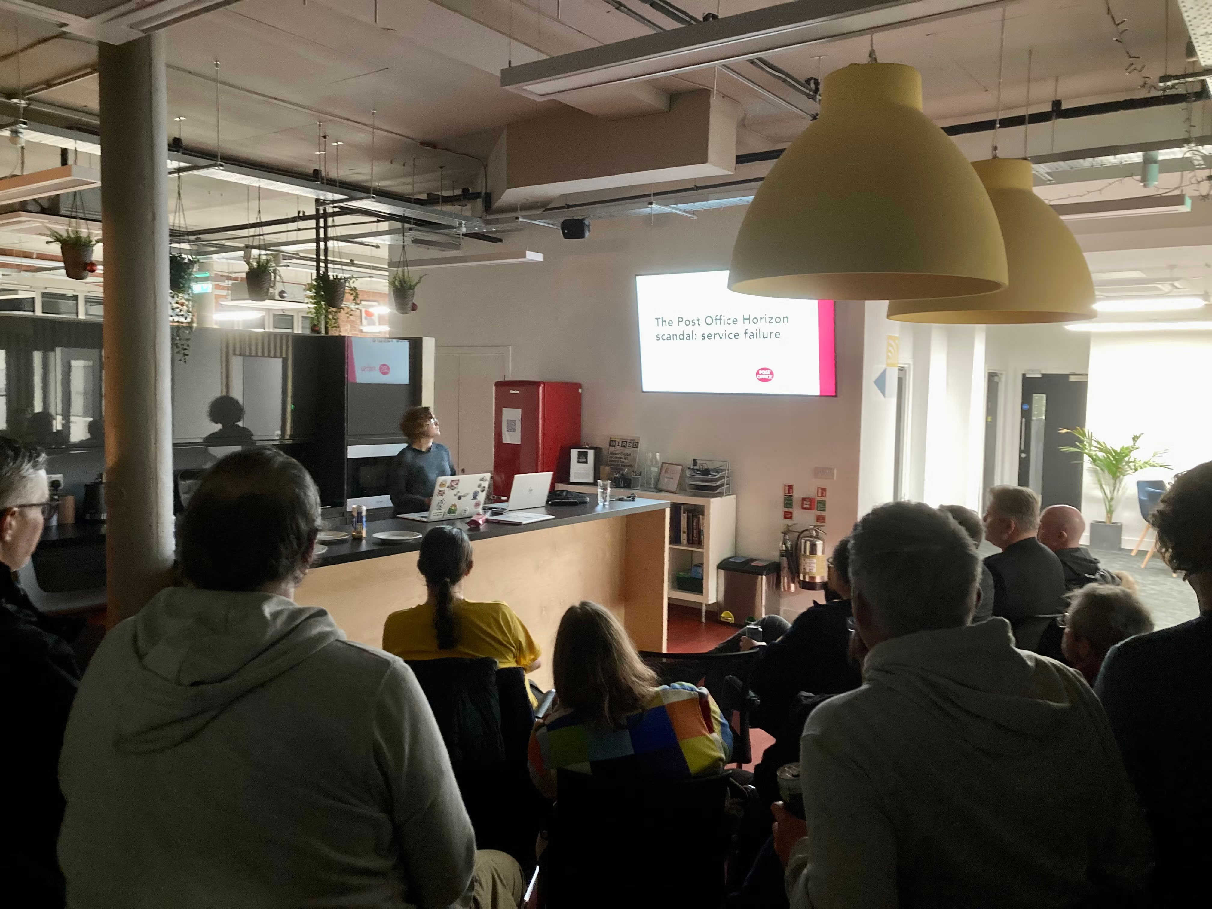 Amy checks her opening slide, before beginning her talk. View from back of audience.