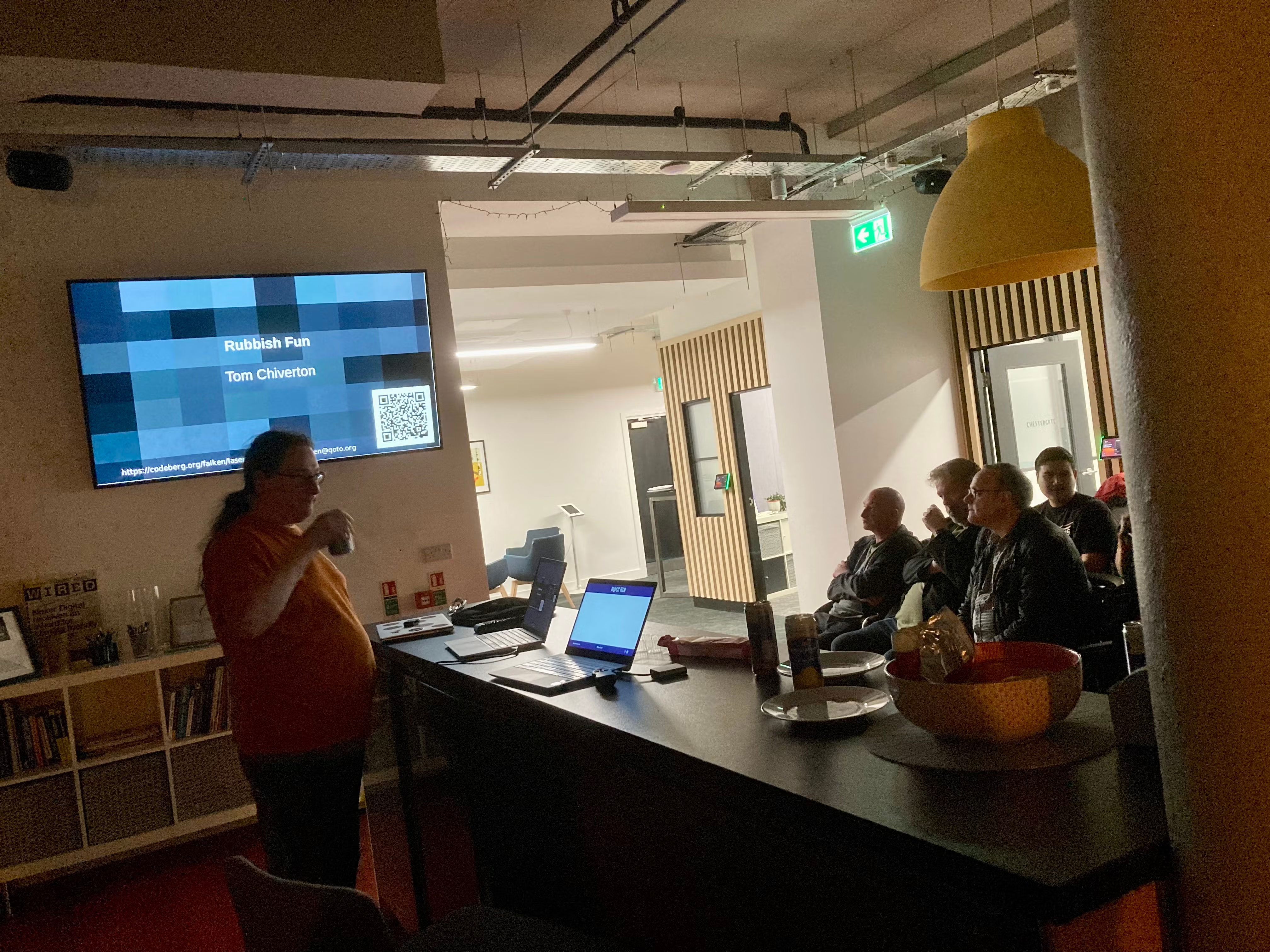 Tom taking a drink before starting his talk. Audience watching.