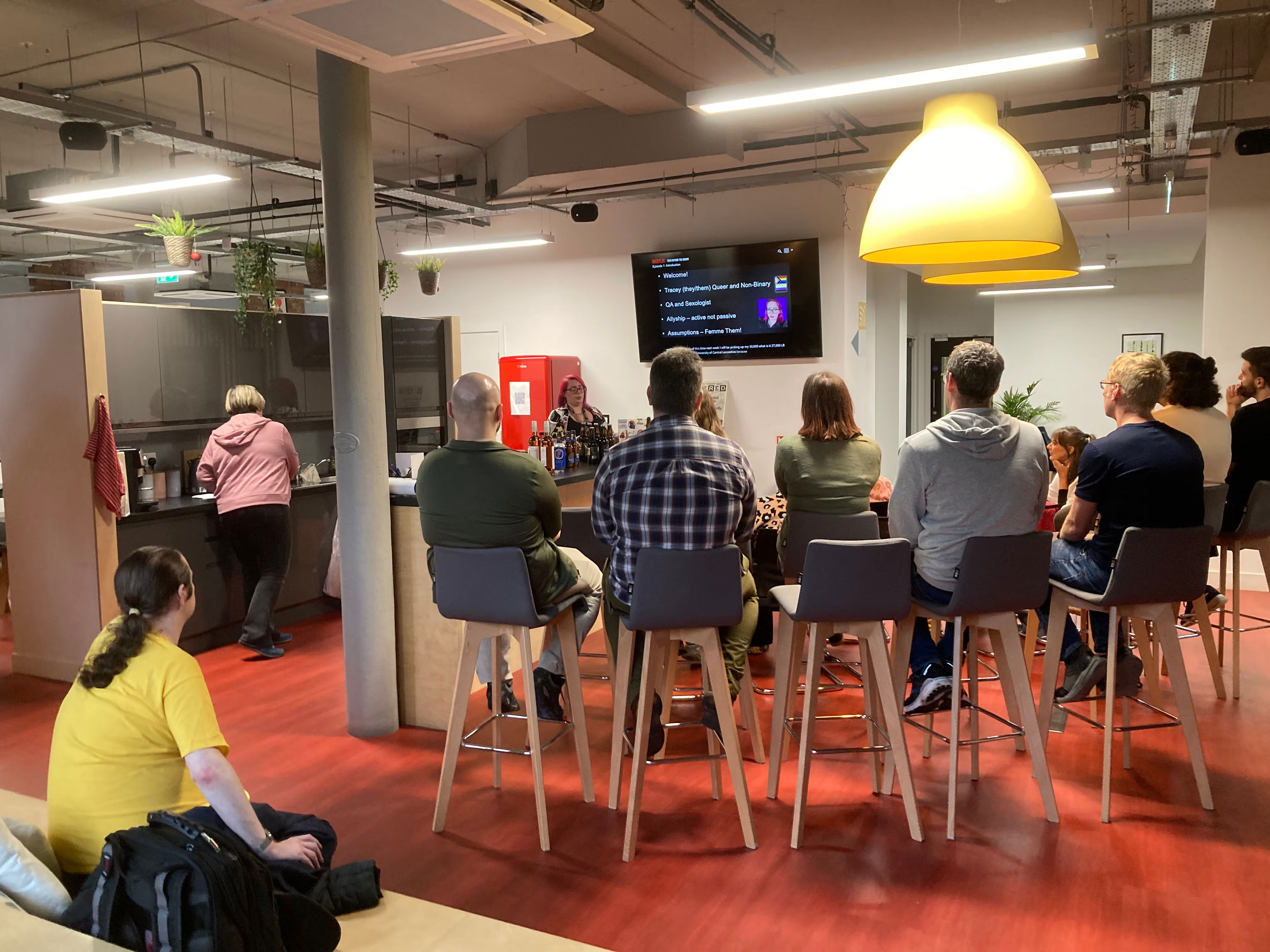 Audience watching Tracey's talk. From the back.