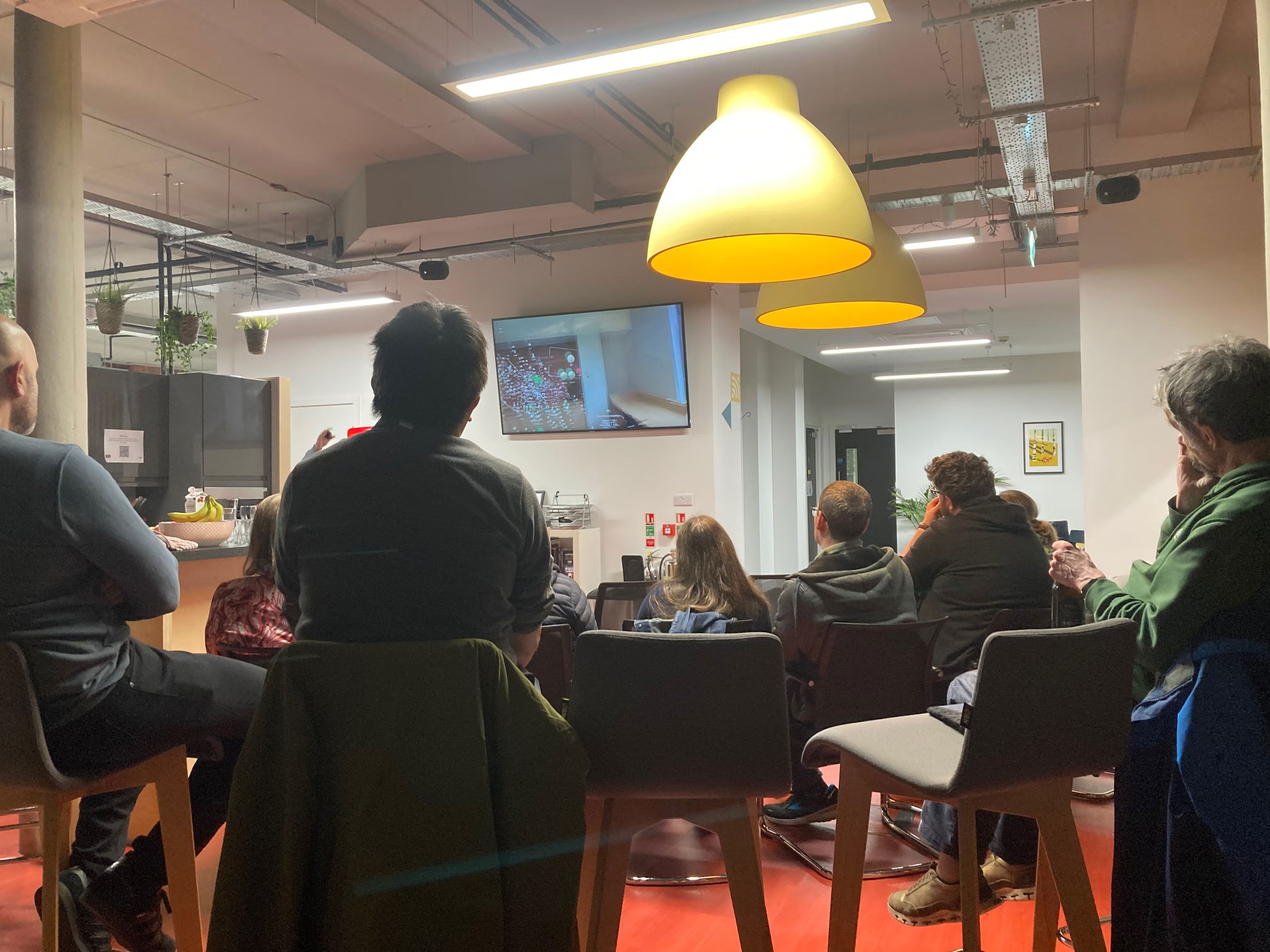 Audience captivated by a demo on the big screen.